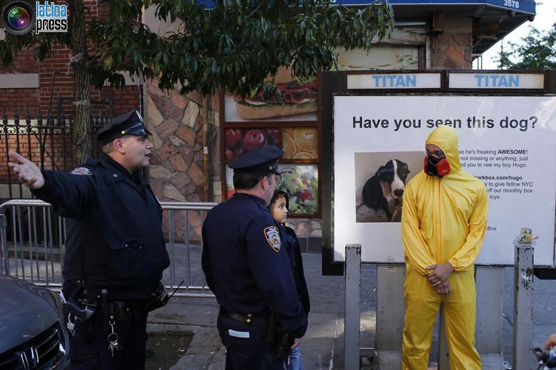 Ufficiali 3NYPD chiedono un uomo che indossa dispositivi di protezione individuale come un costume di Halloween, di allontanarsi dalla zona vicino all'edificio dove il dottor Craig Spencer vive a New York. EDUARDO MUNOZ / REUTERS 